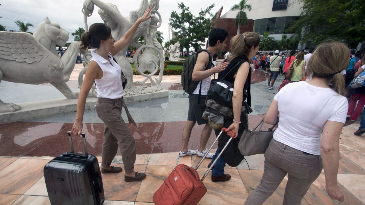 Tourists wait in line at an improvised check-in counter at an airport in Acapulco on September 17.