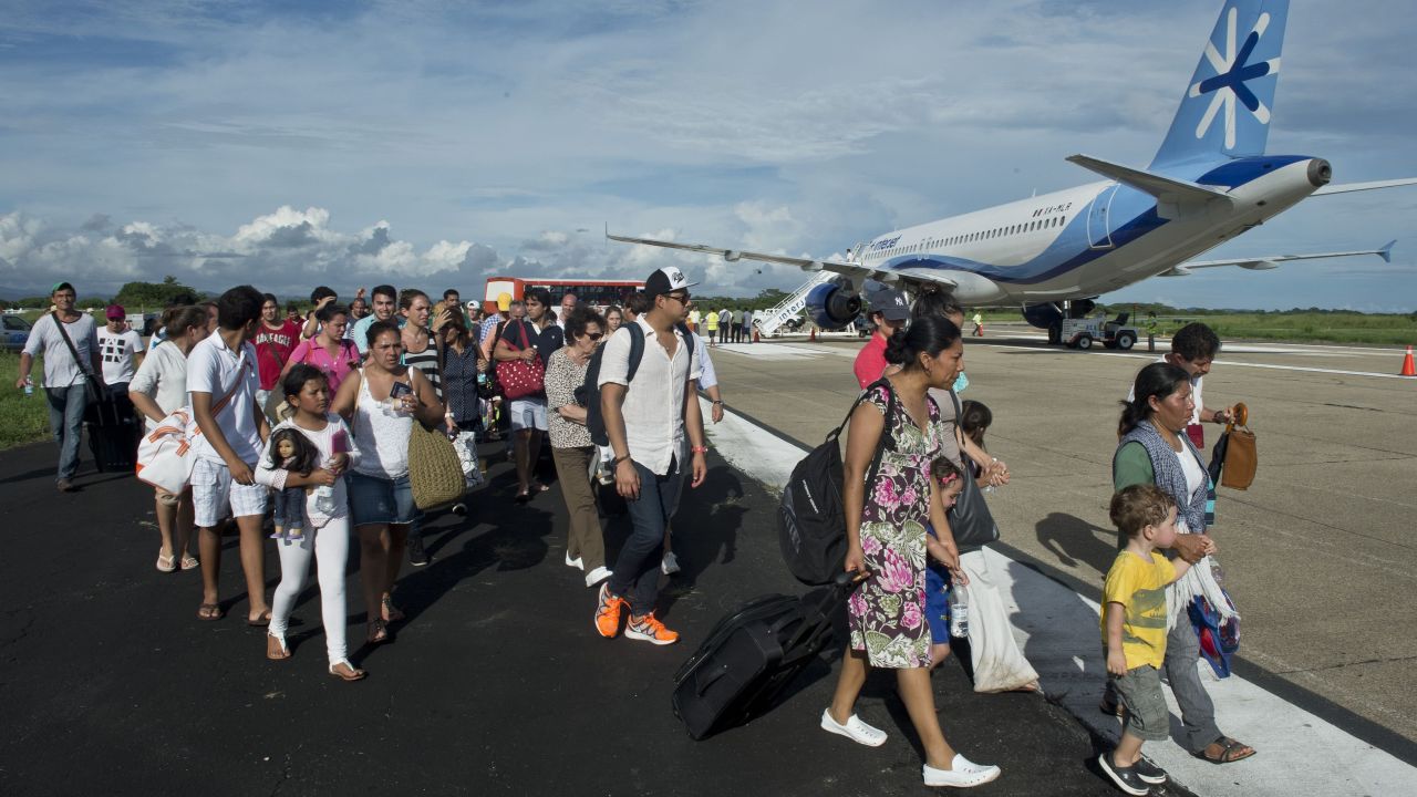 People prepare to board a flight to Mexico City at an airport in Acapulco on September 17.