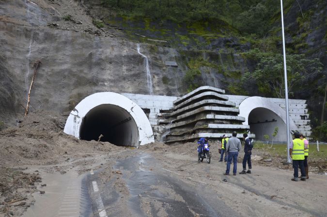 People stand at the entrance of the Agua de Obispo tunnel that connects Acapulco with Chilpancingo, Mexico. The tunnel was badly damaged by the flooding. 
