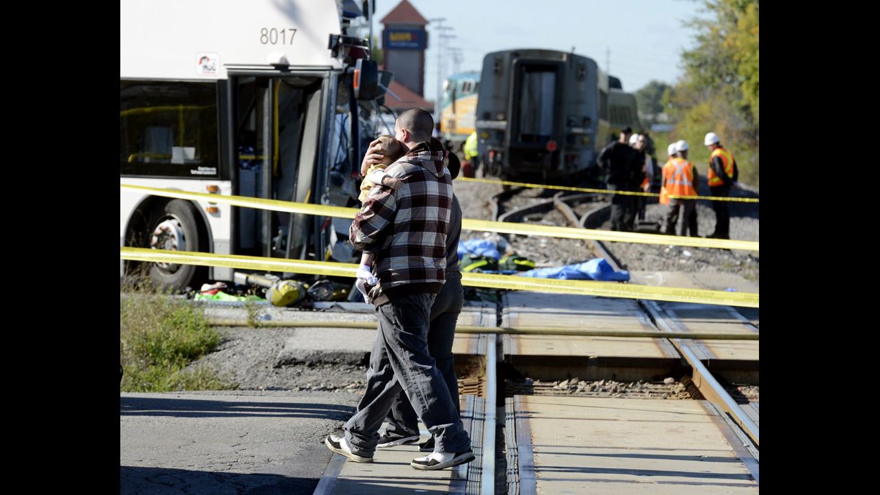 A man carries a child past the scene of the crash on September 18.