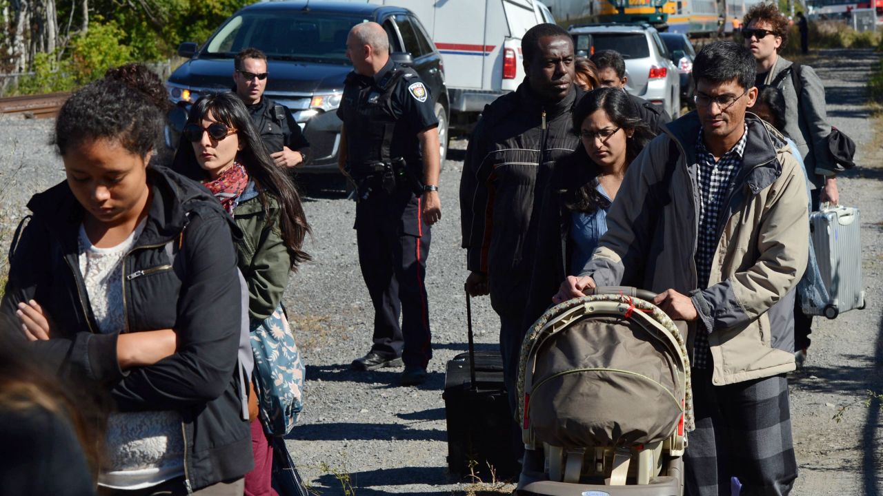 Train passengers are escorted away from the crash site on September 18.