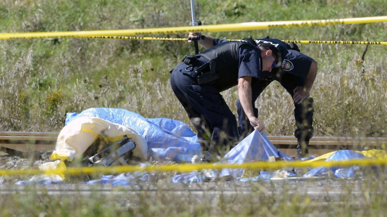 Police officers look under a tarp at the scene on September 18.