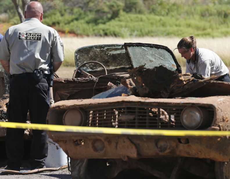 Officials examine one of the cars in September 2013.