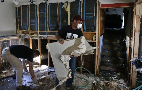 David Soleta, right, and family friend John Rice remove destroyed and contaminated walls on September 18 from Soleta's father-in-law's home, which was heavily damaged by floodwaters that swept through Longmont.