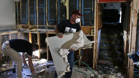 David Soleta, right, and family friend John Rice remove destroyed and contaminated walls on September 18 from Soleta's father-in-law's home, which was heavily damaged by floodwaters that swept through Longmont.