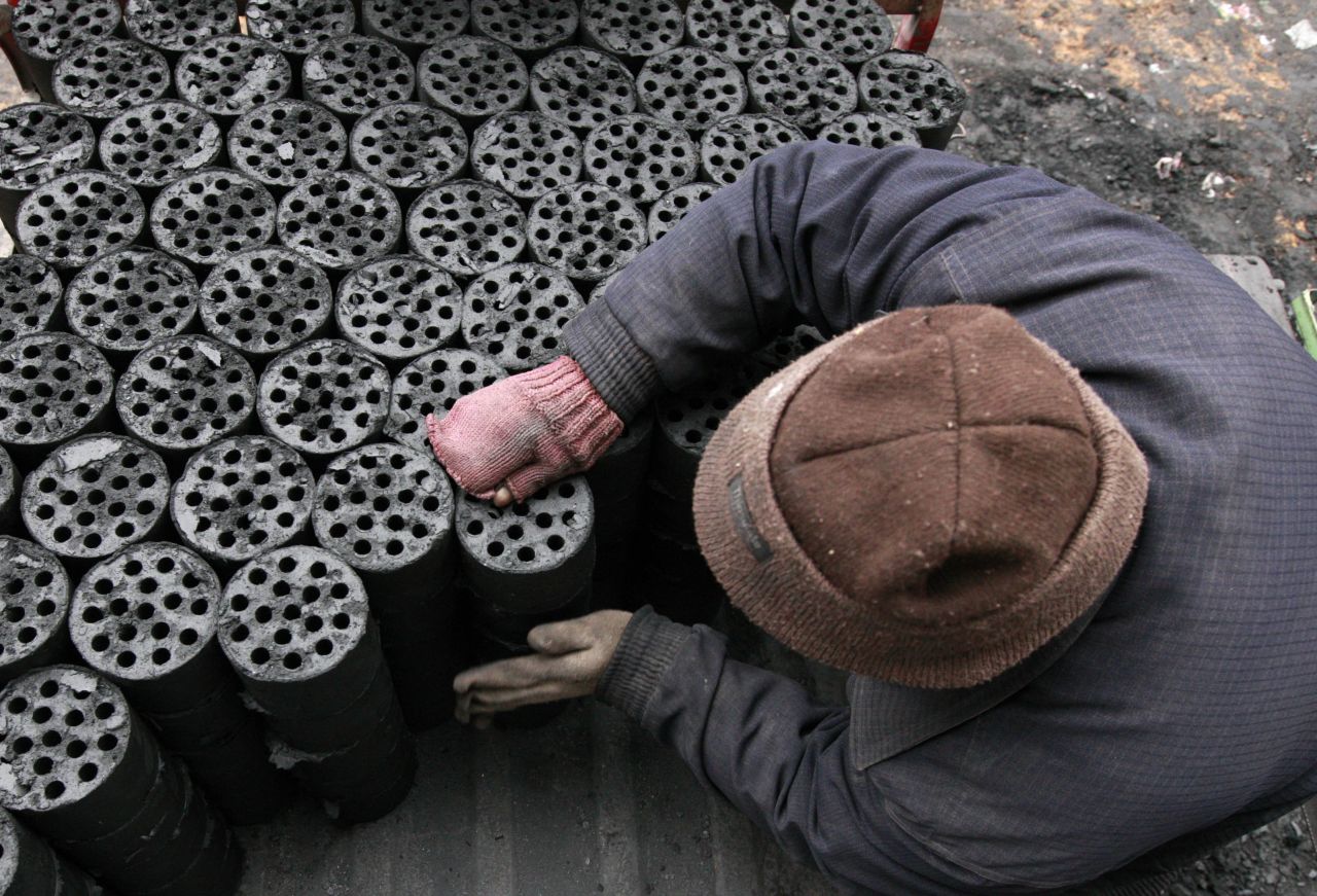 A worker moves coal briquettes onto a pedicab at a coal distribution business in central China's Anhui province in January 2013. Environmental concerns -- particularly over the use of coal -- have been pushed to the top of the national agenda after record air pollution in the past year.