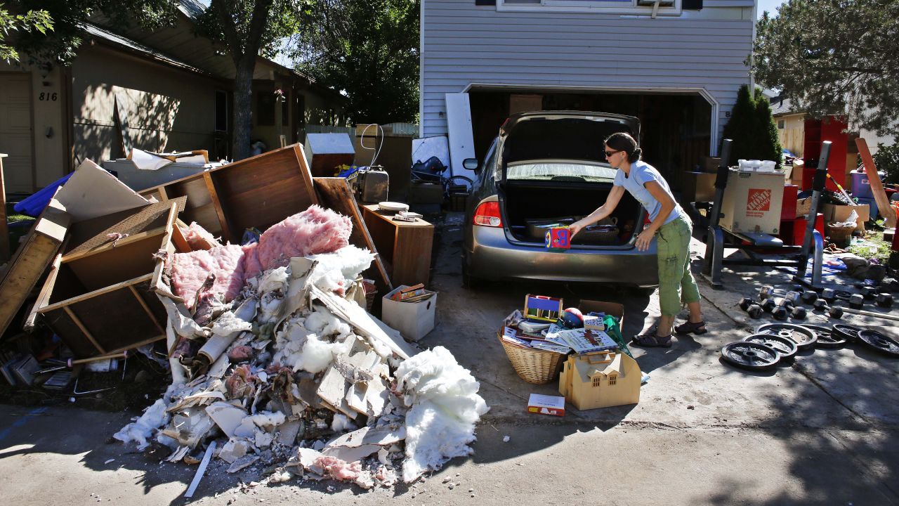 A woman disposes of ruined items from her home in Longmont on Wednesday, September 18.