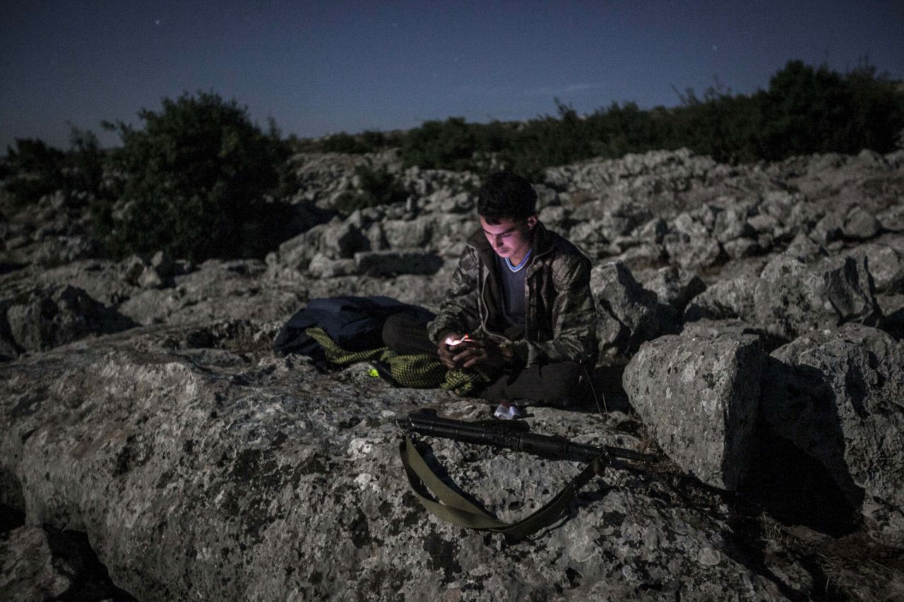 A Syrian opposition fighter takes a break on a mountain near a rebel camp in Idlib province on September 18. 