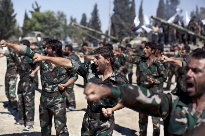 Rebels parade at a former military academy north of Aleppo during a September 13 ceremony to mark an agreement to unite two rebel brigade forces.