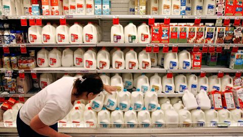 A customer scans the expiration date on gallons of milk sitting at a Safeway grocery store in Washington.