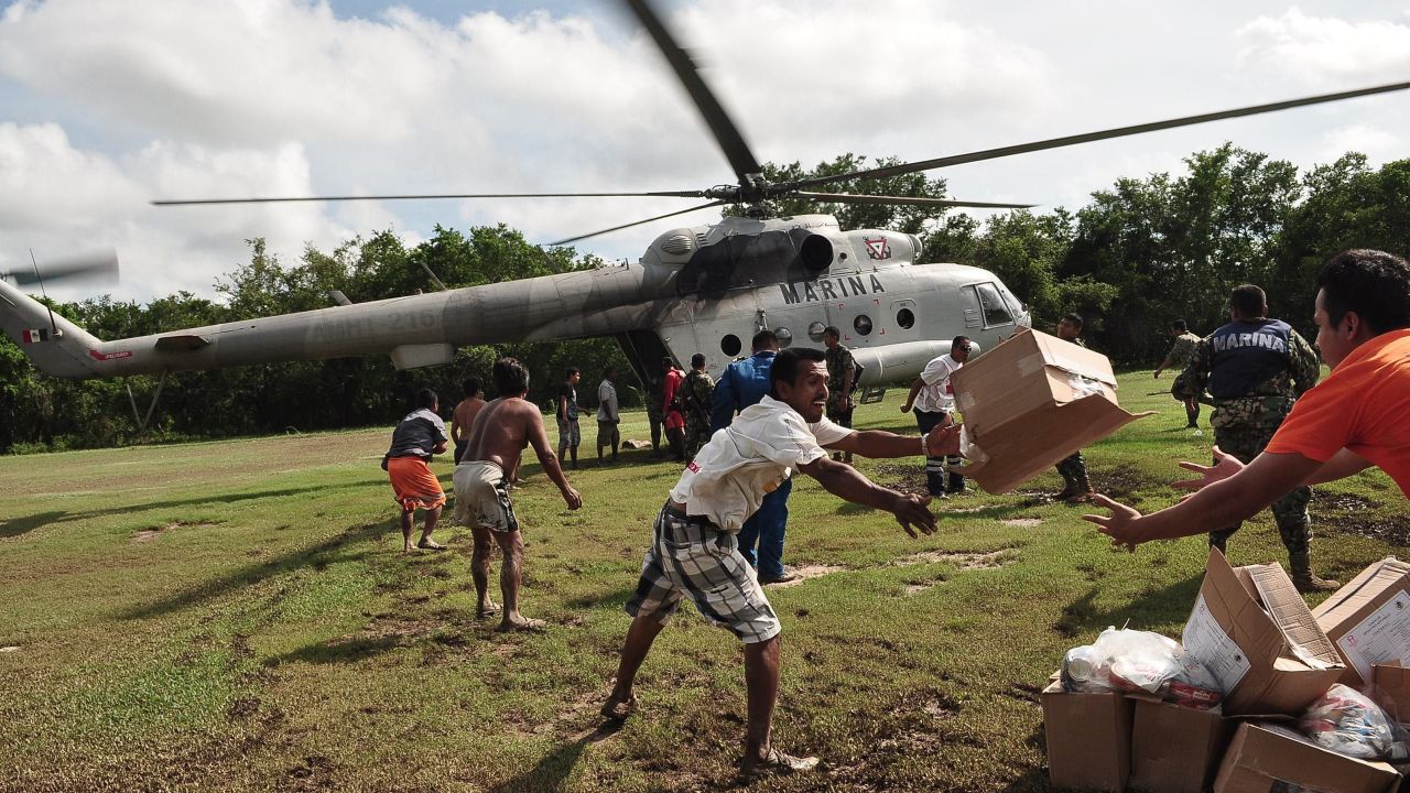 People unload boxes of food from a Mexican navy helicopter in Acapulco on September 18.