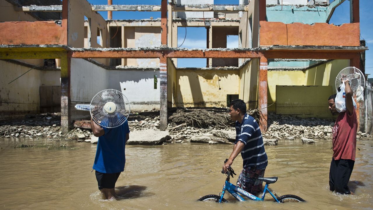 People wade through a flooded street in Acapulco, Mexico, on Wednesday, September 18. 