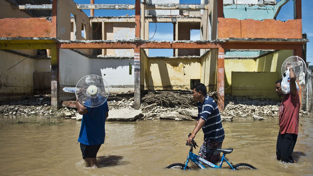 People wade through a flooded street in Acapulco, Mexico, on Wednesday, September 18.