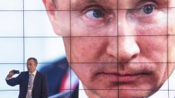 In this handout image provided by Host Photo Agency, a man uses a phone in front of screens showing Russian President Vladimir Putin at the International Media Centre during the G20 Summit on September 5, 2013 in St. Petersburg, Russia. The G20 summit is expected to be dominated by the issue of military action in Syria while issues surrounding the global economy, including tax avoidance by multinationals, will also be discussed duing the two-day summit. (Photo by Alexey Maishev/Host Photo Agency via Getty Images