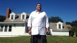Former NFL offensive lineman Brian Holloway stands in front of his rural vacation home Wednesday, Sept. 18, 2013, in Stephentown, N.Y. Holloway's rural vacation home was trashed during a Labor Day weekend party attended by an estimated 200 to 400 teenagers. Holloway said the partiers caused at least $20,000 in damage, breaking windows and doors, punching holes in walls and spraying graffiti. He saw the whole thing unfold live on Twitter _ and now he's using the teens' own posts to reveal their identities and to try to set them on a better path. (AP Photo/Michael Hill)