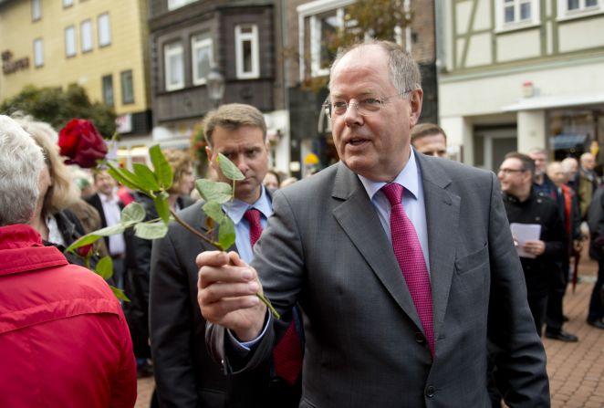 Peer Steinbrueck, the social democrat Chancellor candidate and<a href="index.php?page=&url=http%3A%2F%2Fwww.cnn.com%2F2013%2F09%2F20%2Fworld%2Feurope%2Fgermany-merkel-profile%2Findex.html%3Fhpt%3Dhp_c1"> Angela Merkel</a>'s main challenger, hands out roses to well-wishers in German town of Peine on September 16, 2013. 