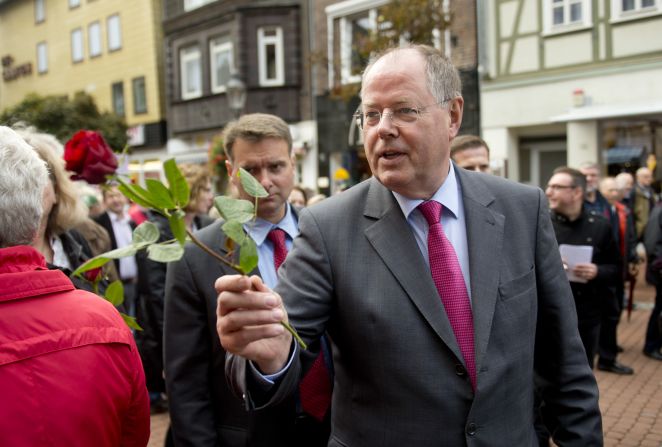 Peer Steinbrueck, the social democrat Chancellor candidate and<a href="index.php?page=&url=http%3A%2F%2Fwww.cnn.com%2F2013%2F09%2F20%2Fworld%2Feurope%2Fgermany-merkel-profile%2Findex.html%3Fhpt%3Dhp_c1"> Angela Merkel</a>'s main challenger, hands out roses to well-wishers in German town of Peine on September 16, 2013.