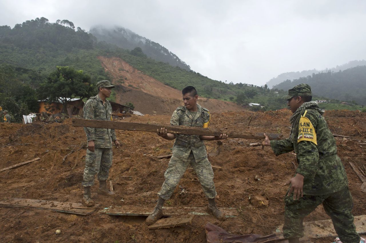 Mexican soldiers search for bodies on the site of a landslide in La Pintada, Mexico, on Thursday, September 19 as heavy rains hit the country.