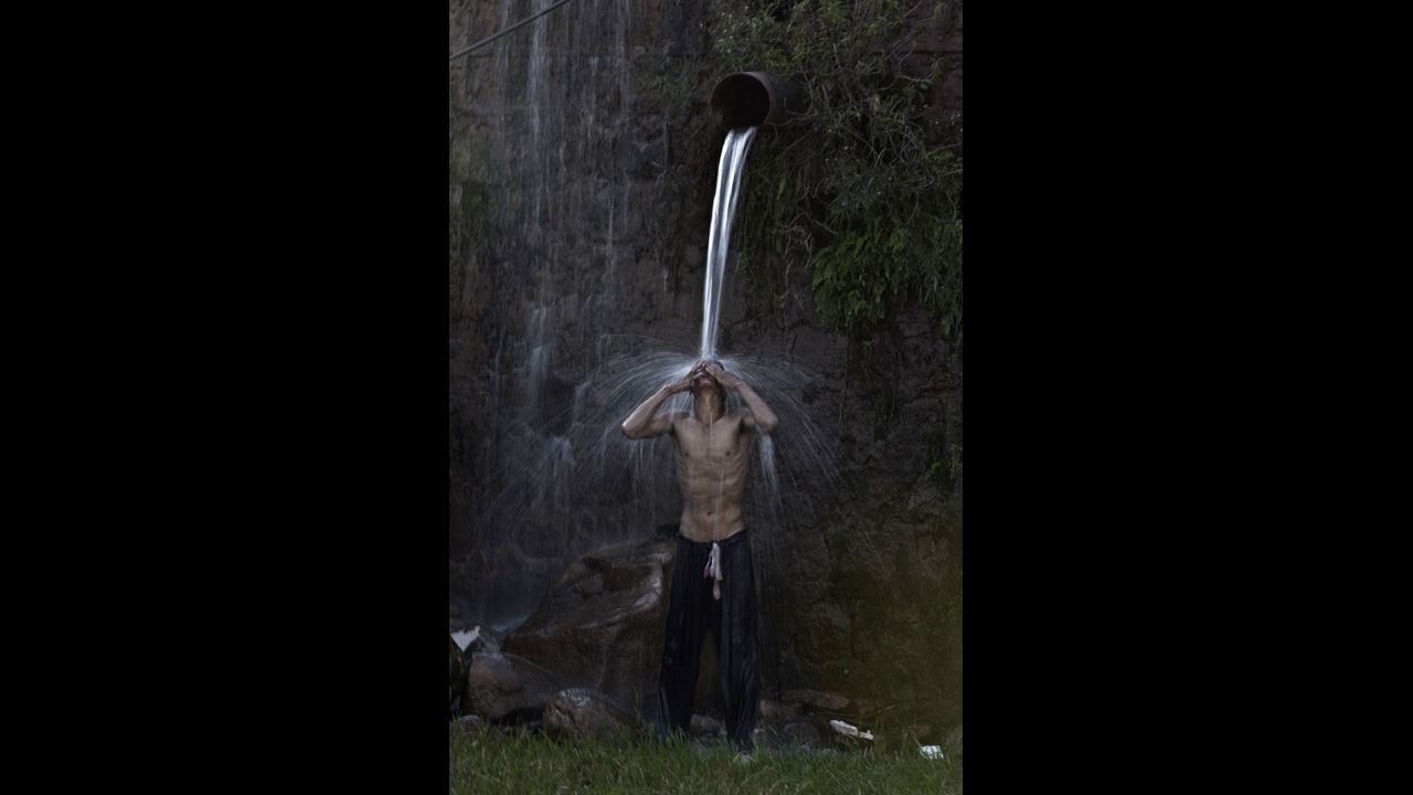 A man takes a shower under a leaking water pipe after work September 19 in Islamabad, Pakistan. The Pakistani people are facing a shortage of clean drinking water because of the low level of water in the country's dams.