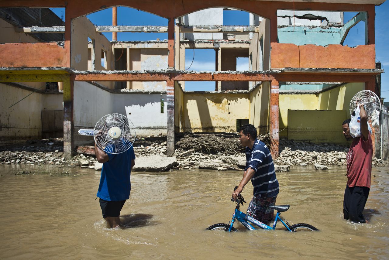 Local residents wade through the flooded street in Acapulco, Mexico, as heavy rains hit the country on September 18. 