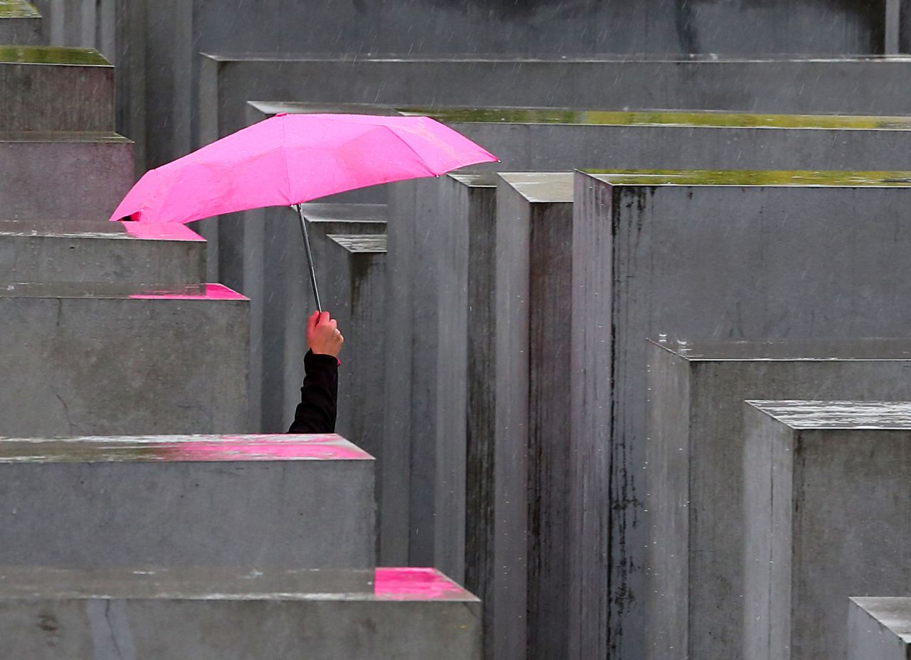 A person with a pink umbrella walks through the Holocaust Memorial on September 18 during rainy weather in Berlin, Germany.