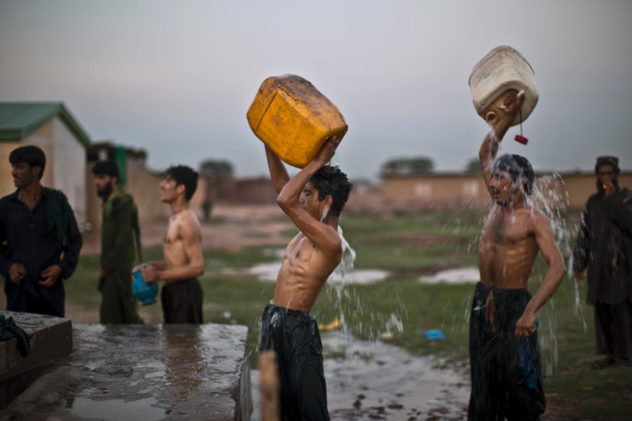 Following their workday, Afghan refugees shower at a public water point on the outskirts of Islamabad, Pakistan, on Tuesday, September 17.