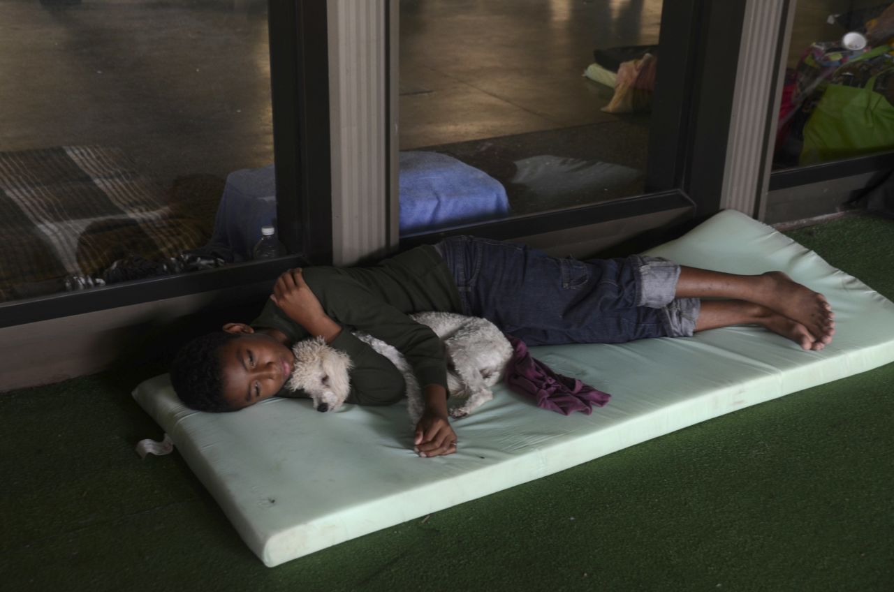 A child lies with his dog at a shelter set up for people affected by Tropical Storm Manuel in the city of Acapulco, Mexico, on September 17.