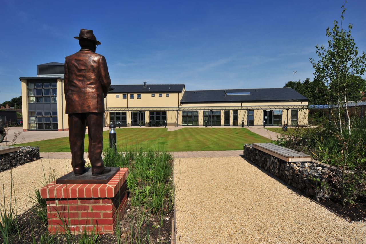 A statue of IJF founder Lord Oaksey surveys the state-of-the-art rehabilitation center that bears his name in Lambourn, England. Opened by Princess Anne in 2009, Oaksey House caters for anyone who has suffered a severe horse-related injury and has five permanent residents. 