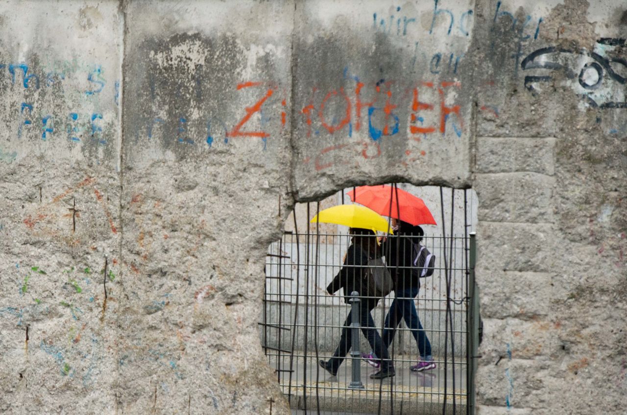 People walk with umbrellas past the exhibition center at the former site of the Nazis' Gestapo and SS headquarters on Friday, September 20, in Berlin. 