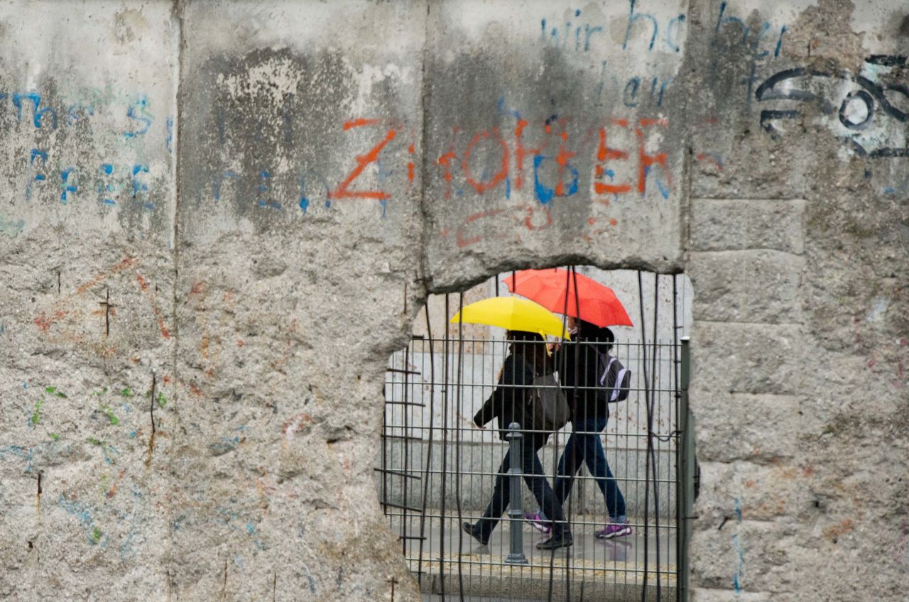 People walk with umbrellas past the exhibition center at the former site of the Nazis' Gestapo and SS headquarters on Friday, September 20, in Berlin.