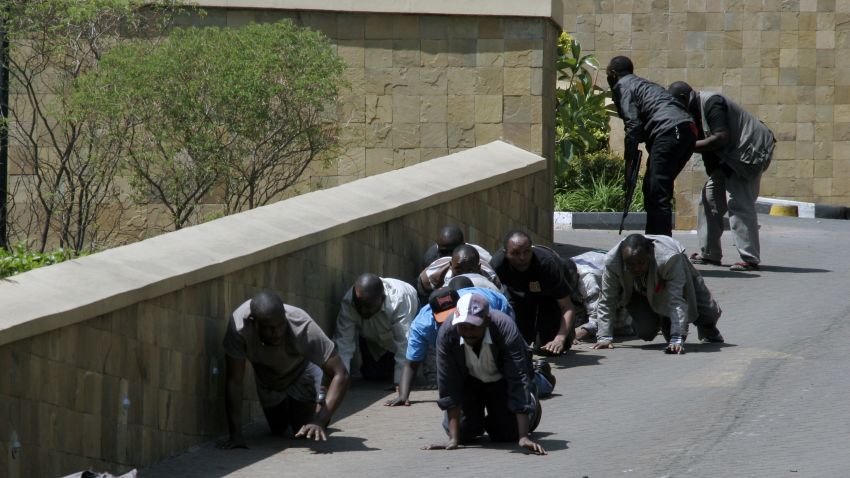 A body, left, lies outside the Westgate Mall, an upscale shopping mall  in Nairobi, Kenya Saturday Sept. 21 2013, where shooting erupted when armed men attempted to rob a shop, according to police. Witnesses say a half dozen grenades also went off along with volleys of  gunfire in and around the mall.  (AP Photo/Sayyid Azim)