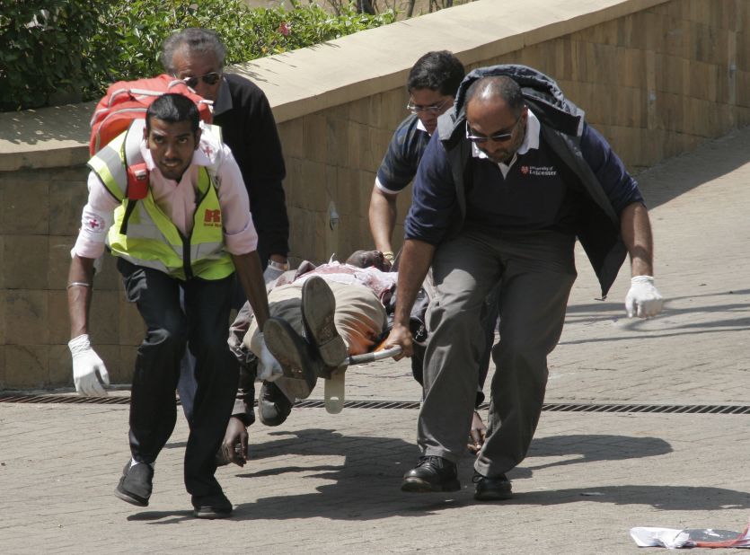 Medical personnel carry a body away. 