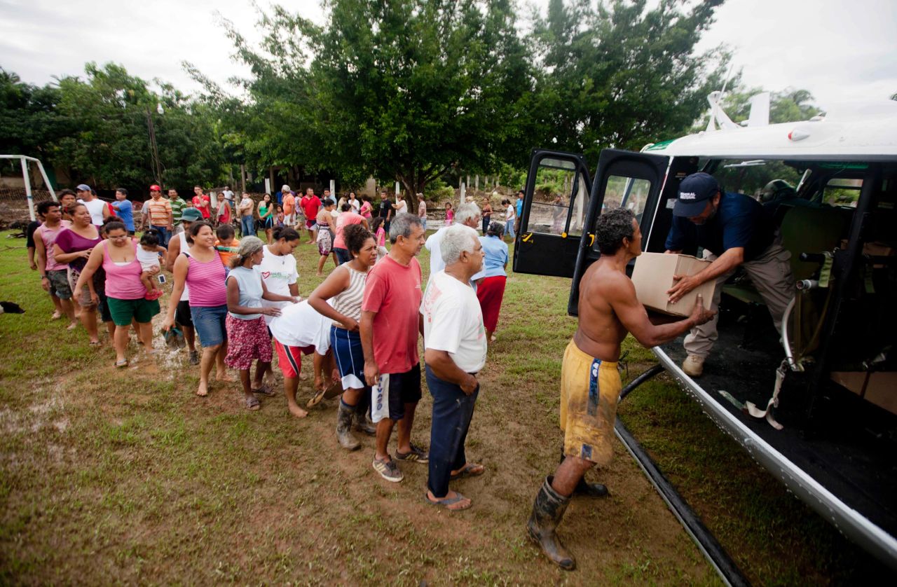 Villagers in San Jeronimo line up at a helicopter from Mexico's Attorney General's Office to get aid on September 20. Federal police have been helping move emergency supplies and bring aid to victims of massive flooding.