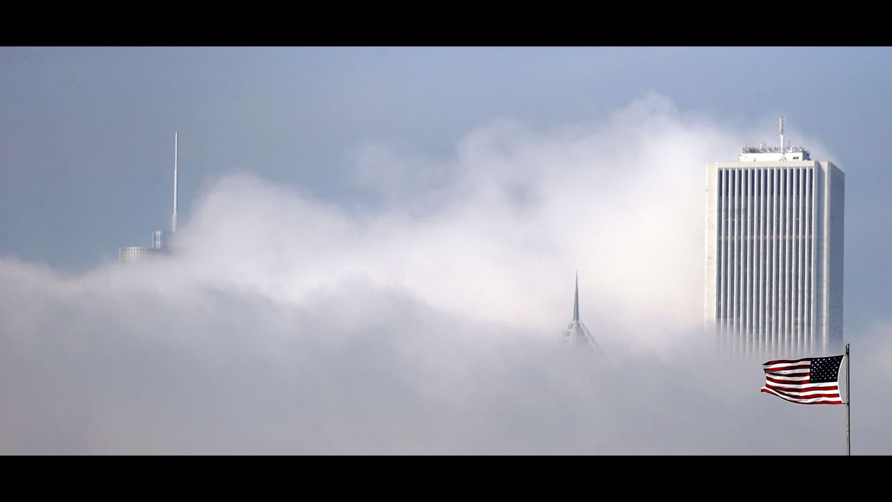 Fog blankets downtown Chicago on Thursday, September 19, leaving the Trump Tower, the Prudential building and the Aon Center barely visible on the skyline as a flag flies over Soldier Field.
