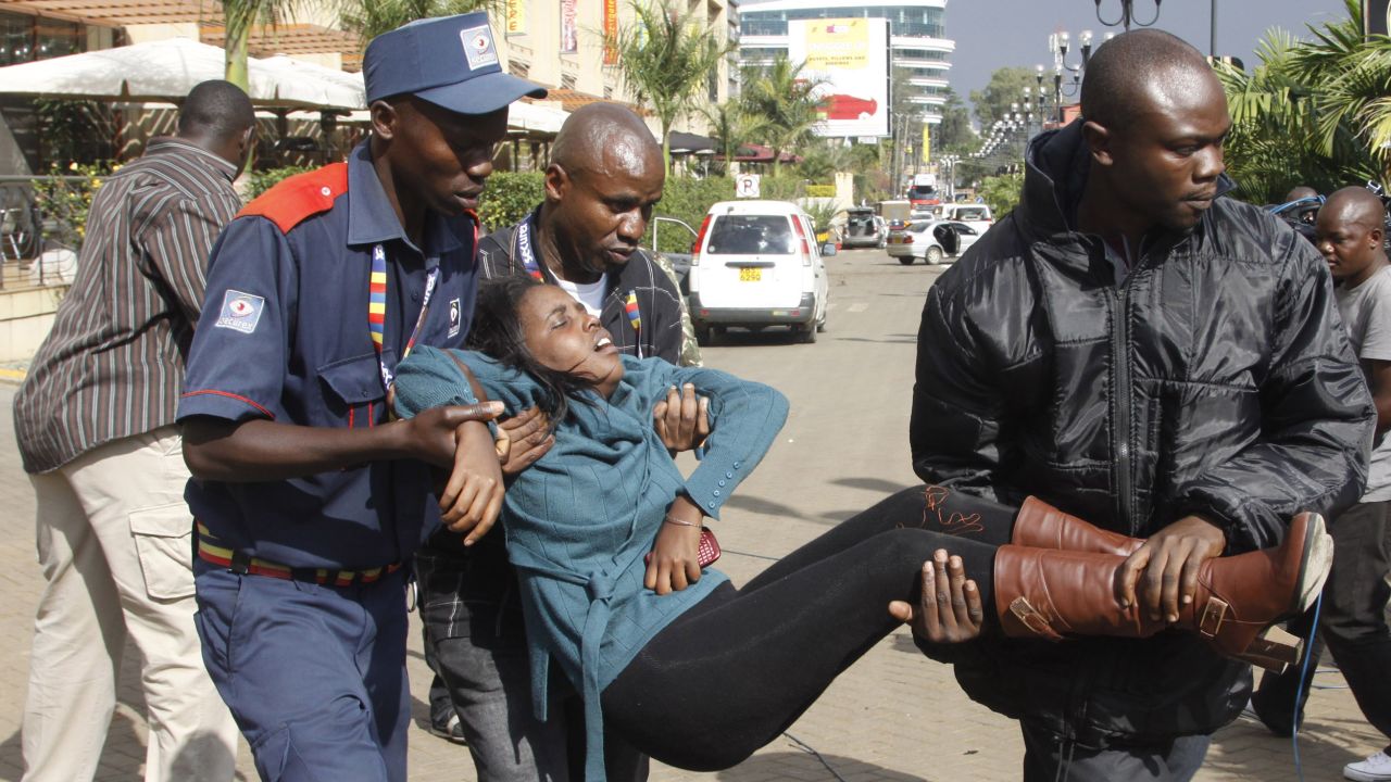 Men help a wounded woman outside the mall.