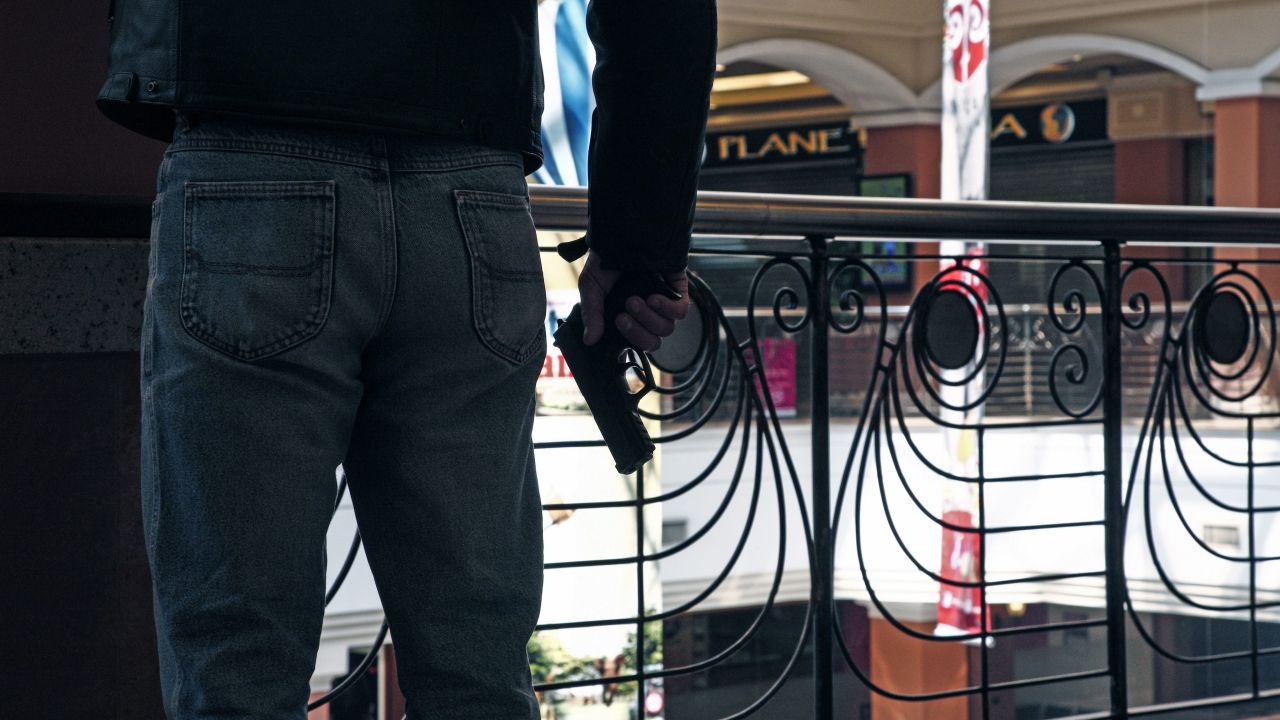 An armed official takes a shooting position inside the mall.