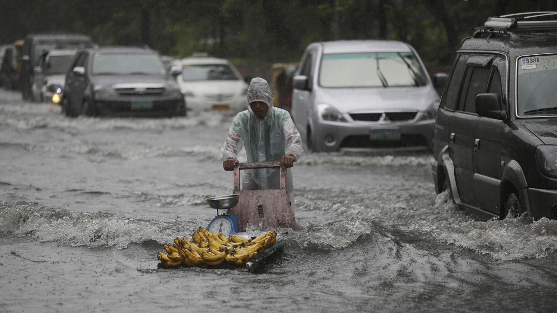 A banana vendor crosses a flooded street on September 22 as monsoon rains from Typhoon Usagi pound Manila, Philippines.