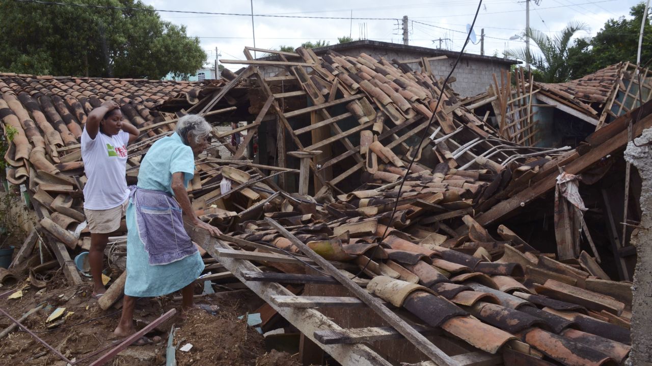 Two women inspect what is left of their home in the village of Salsipuedes, Mexico, on Friday, September 20.
