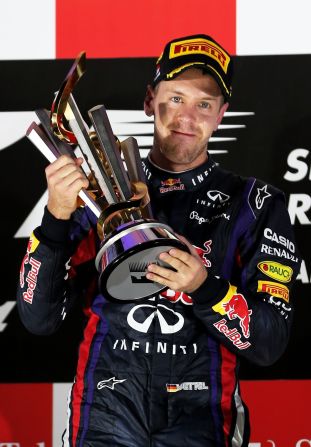 Red Bull's Sebastian Vettel lifts the trophy under lights following his victory at the Singapore Grand Prix, F1's only night race.