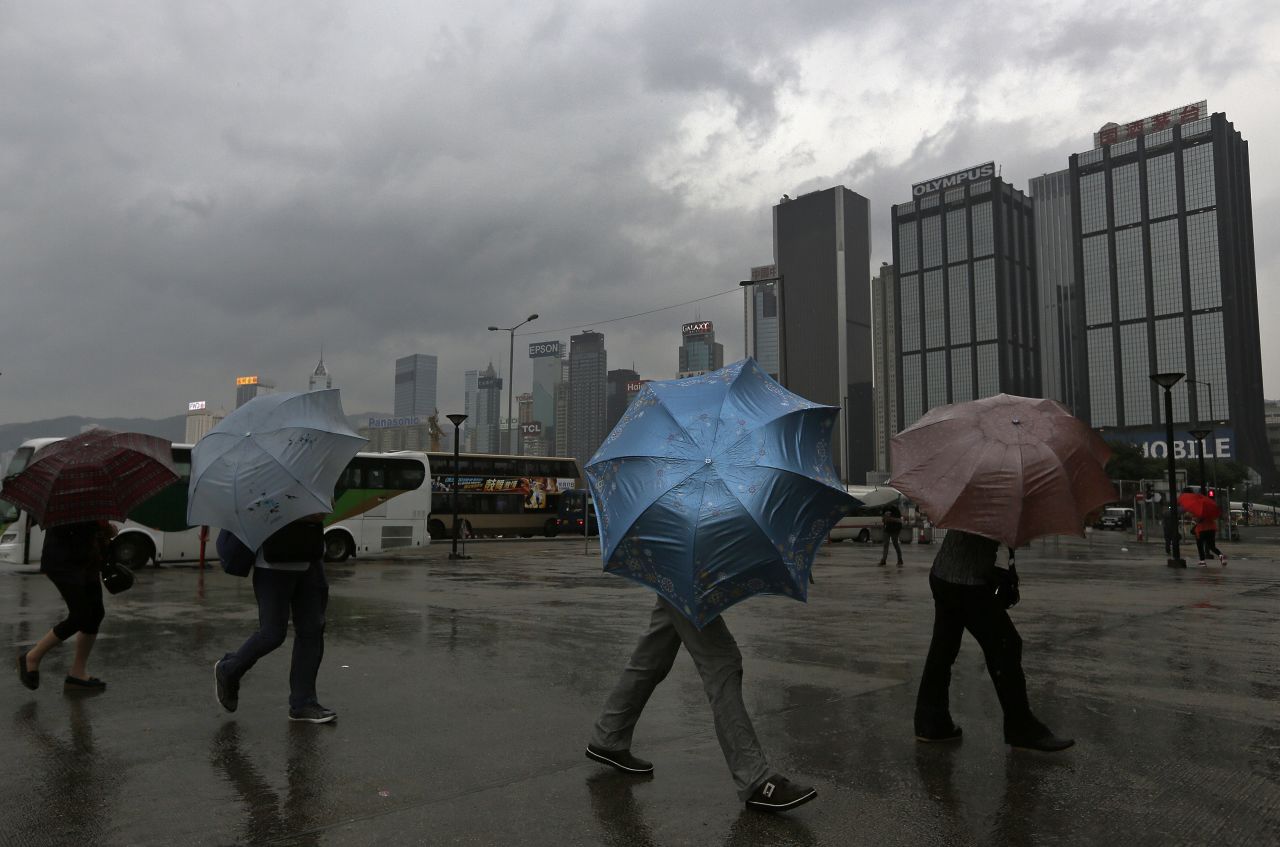 Tourists hang on to their umbrellas near the waterfront in Hong Kong on September 22.