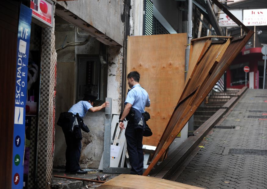 Police officers check for damage caused by Typhoon Usagi at a construction site in Hong Kong on September 23.