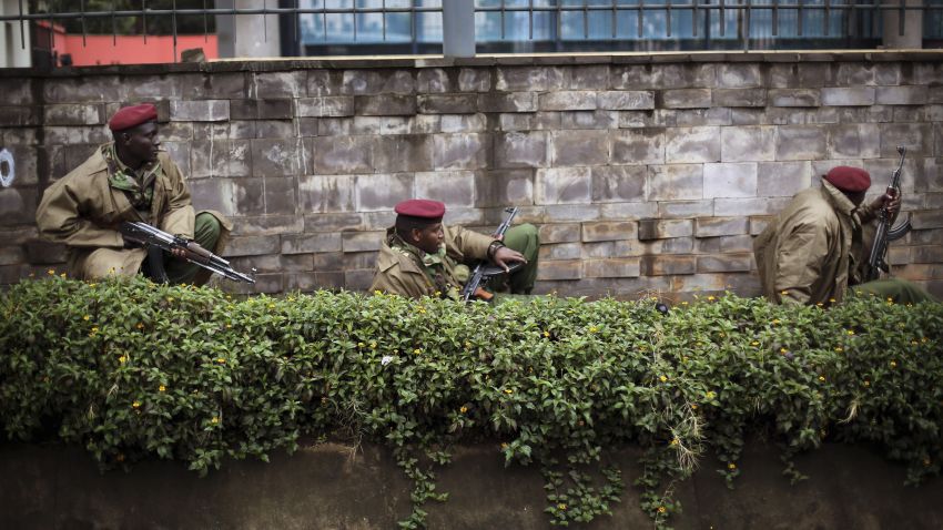 Kenya security forces crouch behind a wall outside the Westgate Mall in Nairobi, Kenya, on Monday, September 23.