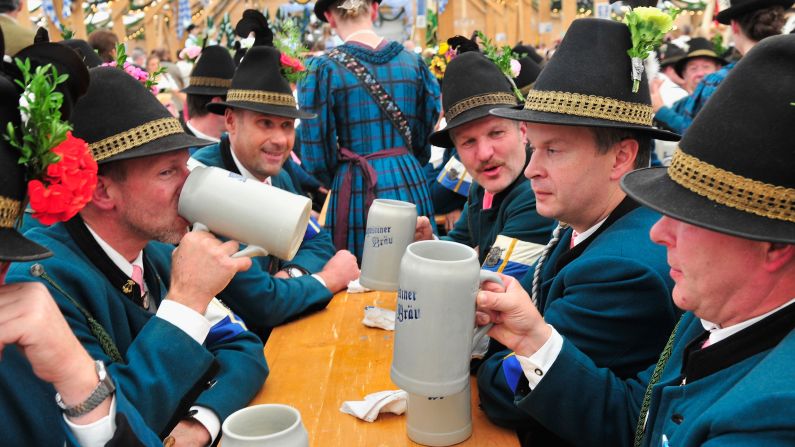 Men dressed in traditional rifleman uniforms drink together at the Oktoberfest 2013 festival in Munich, Germany, on Sunday, September 22. Oktoberfest is the world's largest beer festival and runs September 21 through October 6.