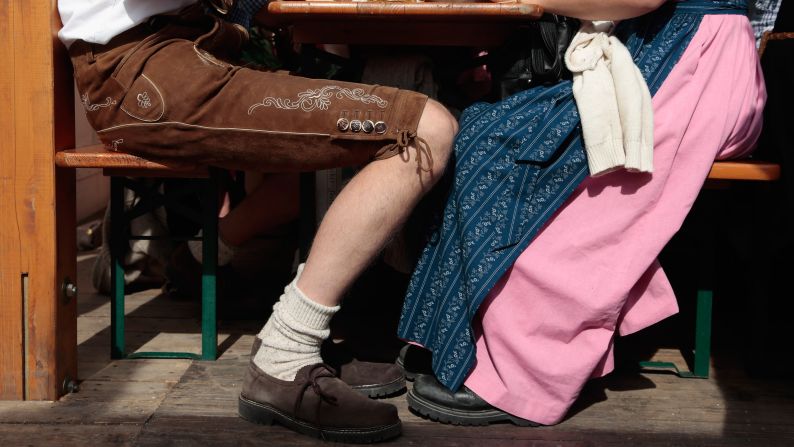 Visitors wearing traditional Bavarian clothes sit outside the Hacker-Pschorr tent.