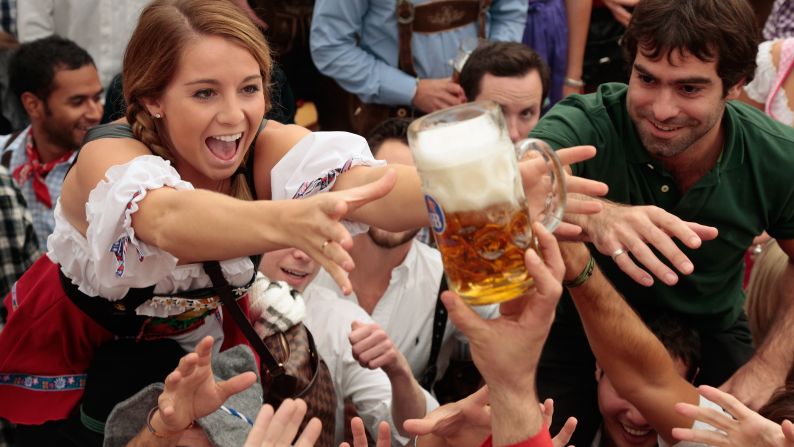 Revelers reach for the first beer mug at the Hofbraeuhaus beer tent during the first day of Oktoberfest, Saturday, September 21.