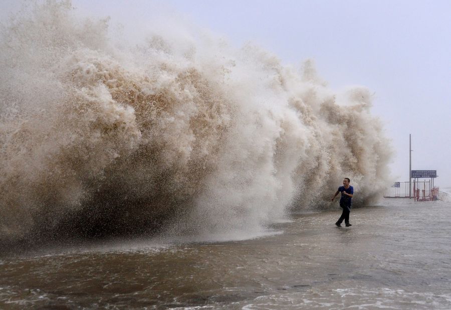 A man runs from a huge wave on a wharf in Shantou, China, on Sunday, September 22.