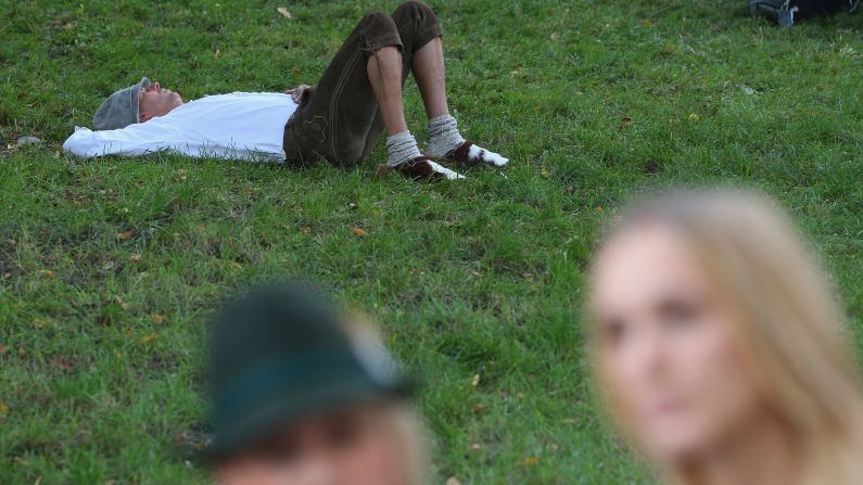 A man rests on a patch of grass on the first day of the festival. <a href="index.php?page=&url=http%3A%2F%2Fwww.cnn.com%2F2013%2F09%2F20%2Ftravel%2Foktoberfest-2013-9-rules%2Findex.html">Here are 9 rules for surviving Oktoberfest.</a>