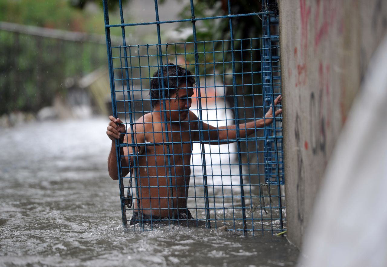 A resident closes the gate of his flooded home in Manila after torrential rains pounded Luzon island on September 23.