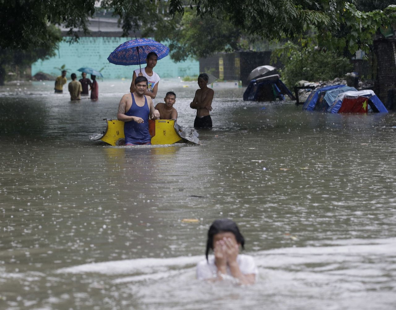 Residents wade through a flooded street in suburban Quezon City, northeast of Manila, on September 23.