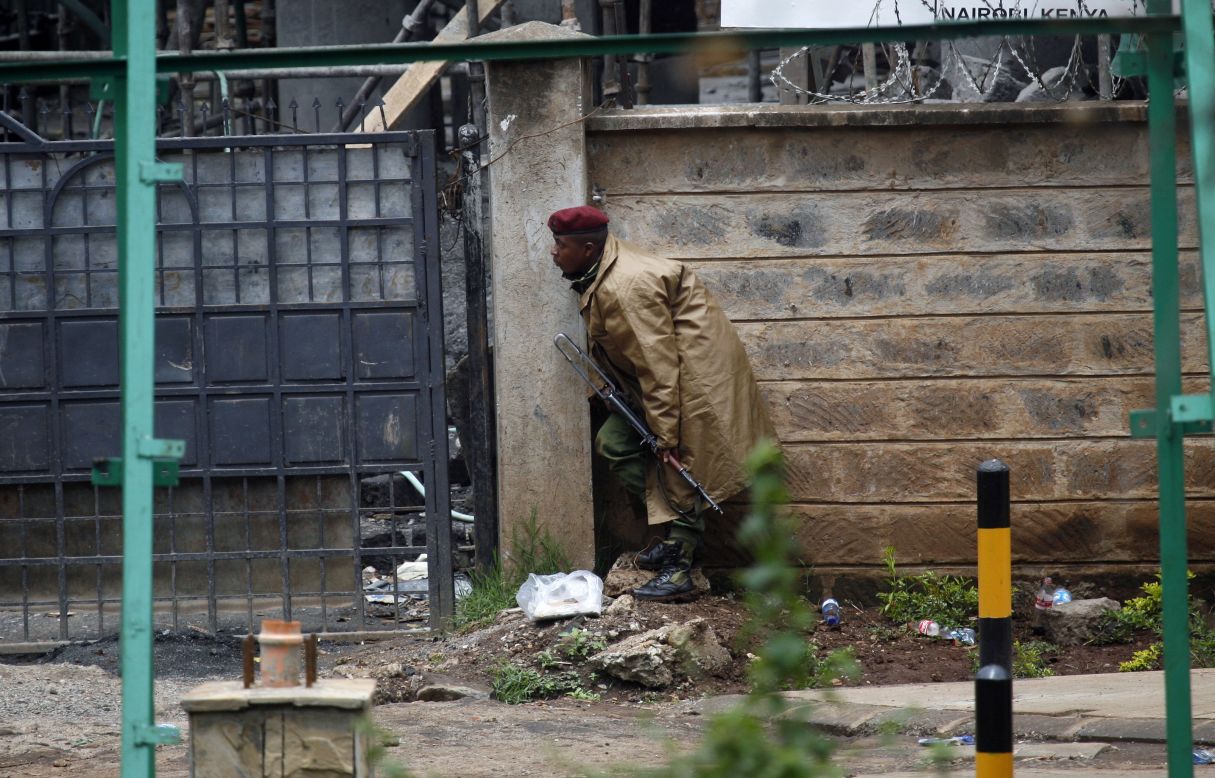 A Kenyan security officer takes cover as gunfire and explosions are heard from the mall on September 23.